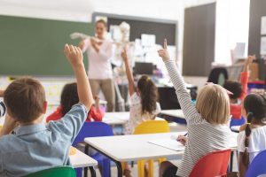 Children in school raising their hands