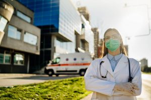 Healthcare worker in front of hospital